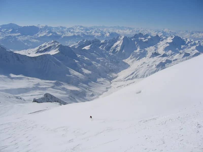 A skier on a wide snow slope above the Aosta Valley after a helicopter drop