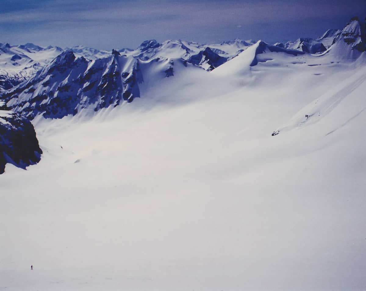 A small group of skiers on a large glacier in the Selkirks